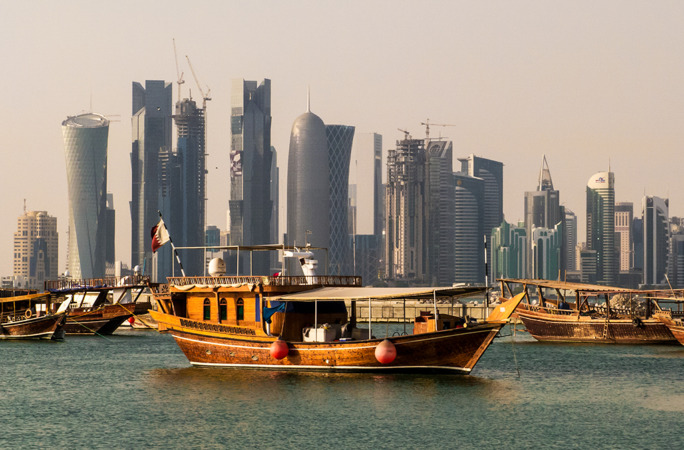 قارب في البحر وخلفه المباني الحديثه في قطر 