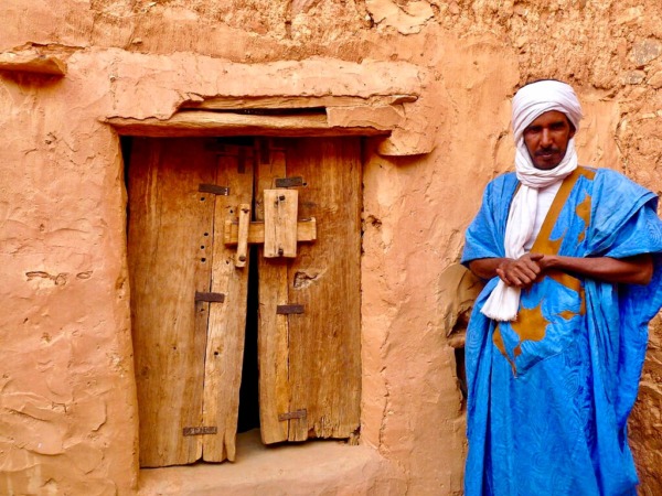 باب و جدار و رجل موريتاني يرتدي ملابس زرقاء
